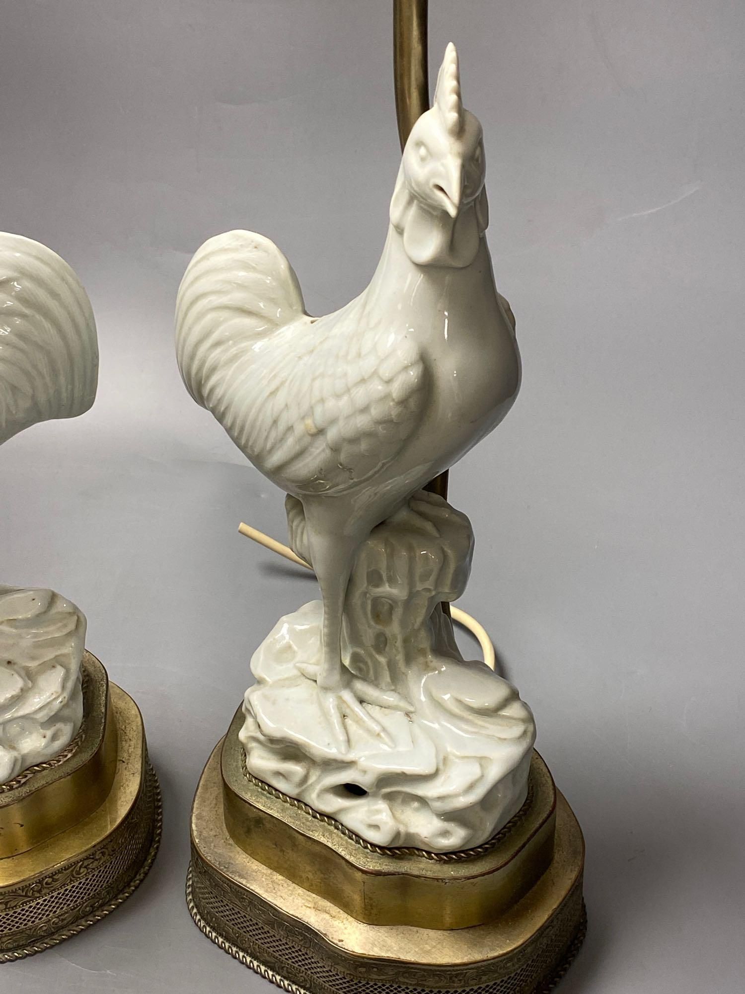 A pair of blanc de chine cockerel lamps, total height 64cm